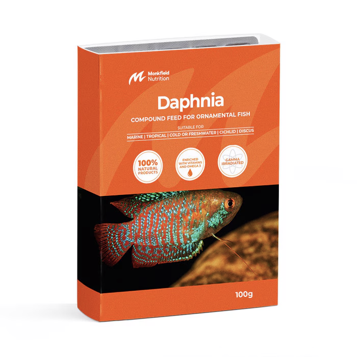 Packaging of Monkfield Nutrition Daphnia compound feed for ornamental fish, featuring an orange box with an image of a colorful tropical fish against a dark background, suitable for marine, tropical, cold, or freshwater, cichlid, and discus fish, enriched with vitamins and omega-3, and gamma irradiated for safety