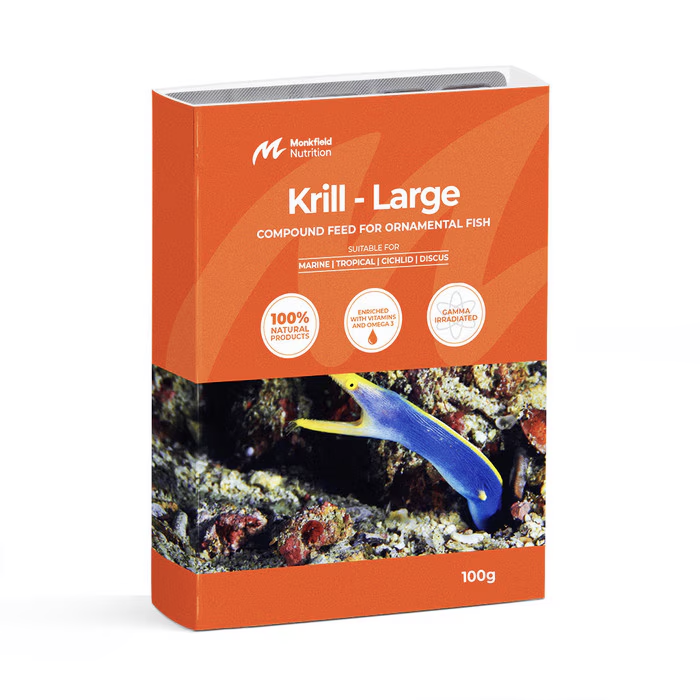 Packaging of Monkfield Nutrition Krill Large compound feed for ornamental fish, featuring an orange box with an image of a marine fish swimming near coral, suitable for marine, cold, or freshwater fish, enriched with vitamins and omega-3, and gamma irradiated for safety.